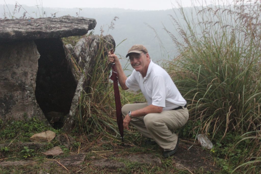 Guest posing near a dolmen in Muttukad during the trek from SpiceTree